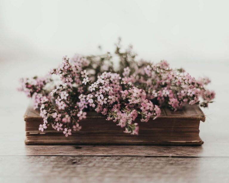 Pink flowers on book representing romance novels by Ink & Income