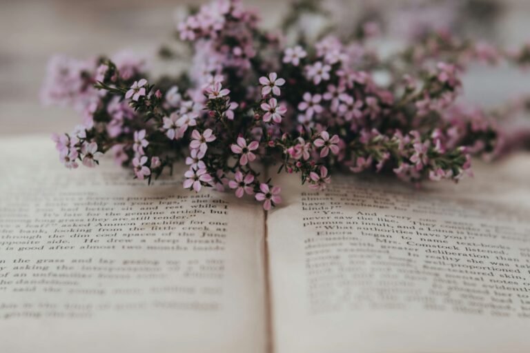 Pink flowers on an open book representing romance novels by Ink & Income